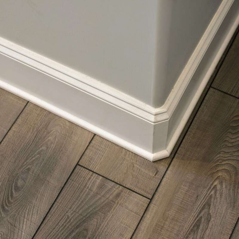 detailed baseboard and curved corner finish close-up with flooring