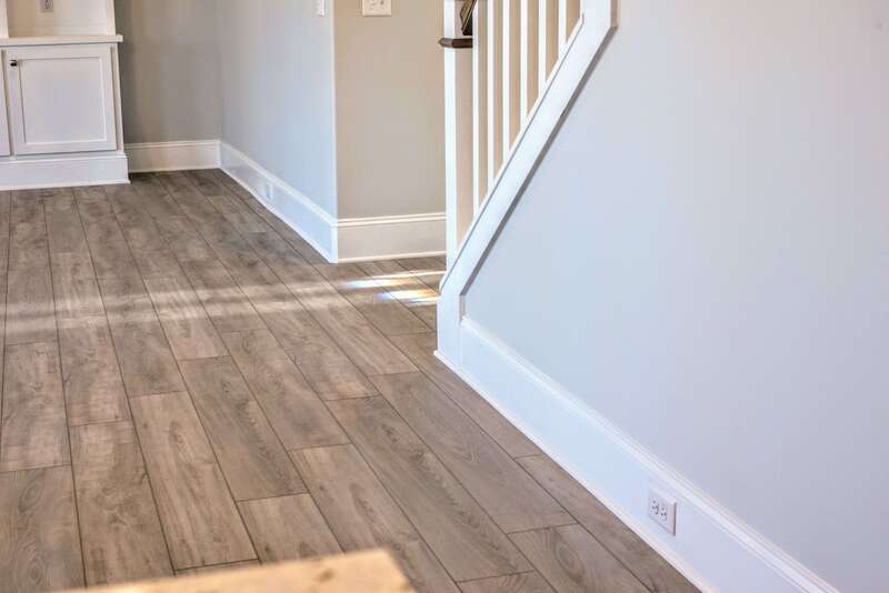 mid-range view of stairwell, floor, and baseboards, especially the electric sockets along the baseboards, exceeding code standards
