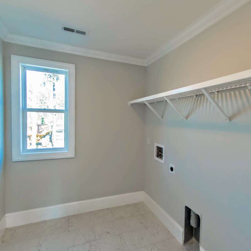 laundry room with window, shelving, and tile floors
